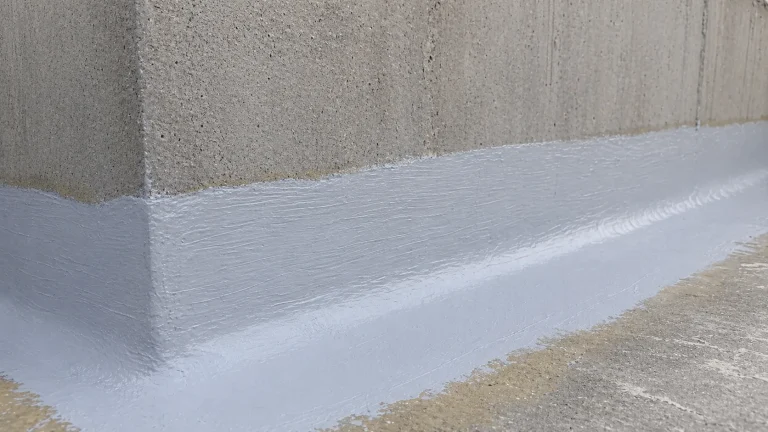 Finished detail of BW6-9526 hand-applied polyurea waterproof protective coating at a concrete wall corner