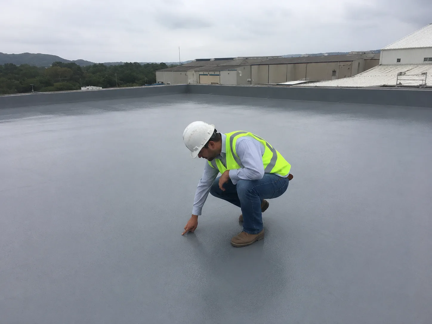 Polyurea application guide showing final inspection of a completed waterproofing membrane on a concrete roof