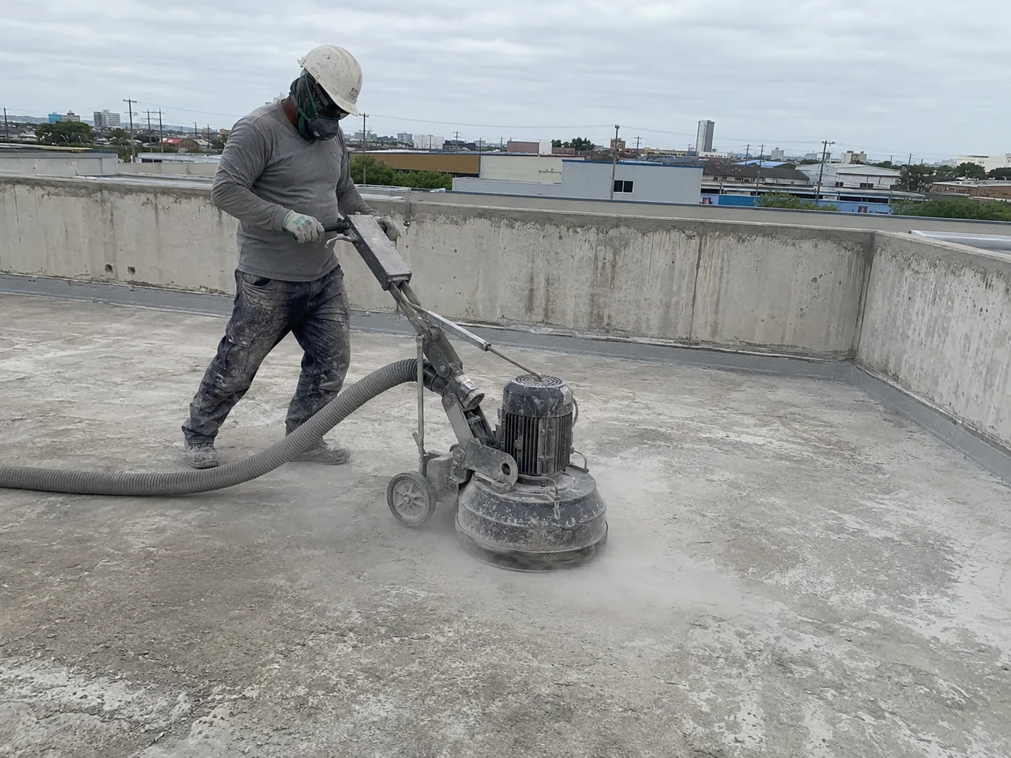 Polyurea substrate preparation with concrete roof grinding before primer and coating application