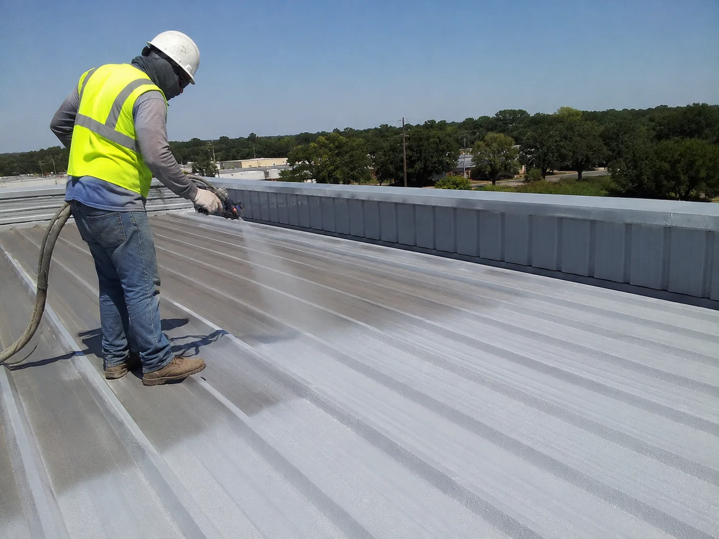 Spray polyurea roof coating application on a metal roof for waterproofing and industrial protection