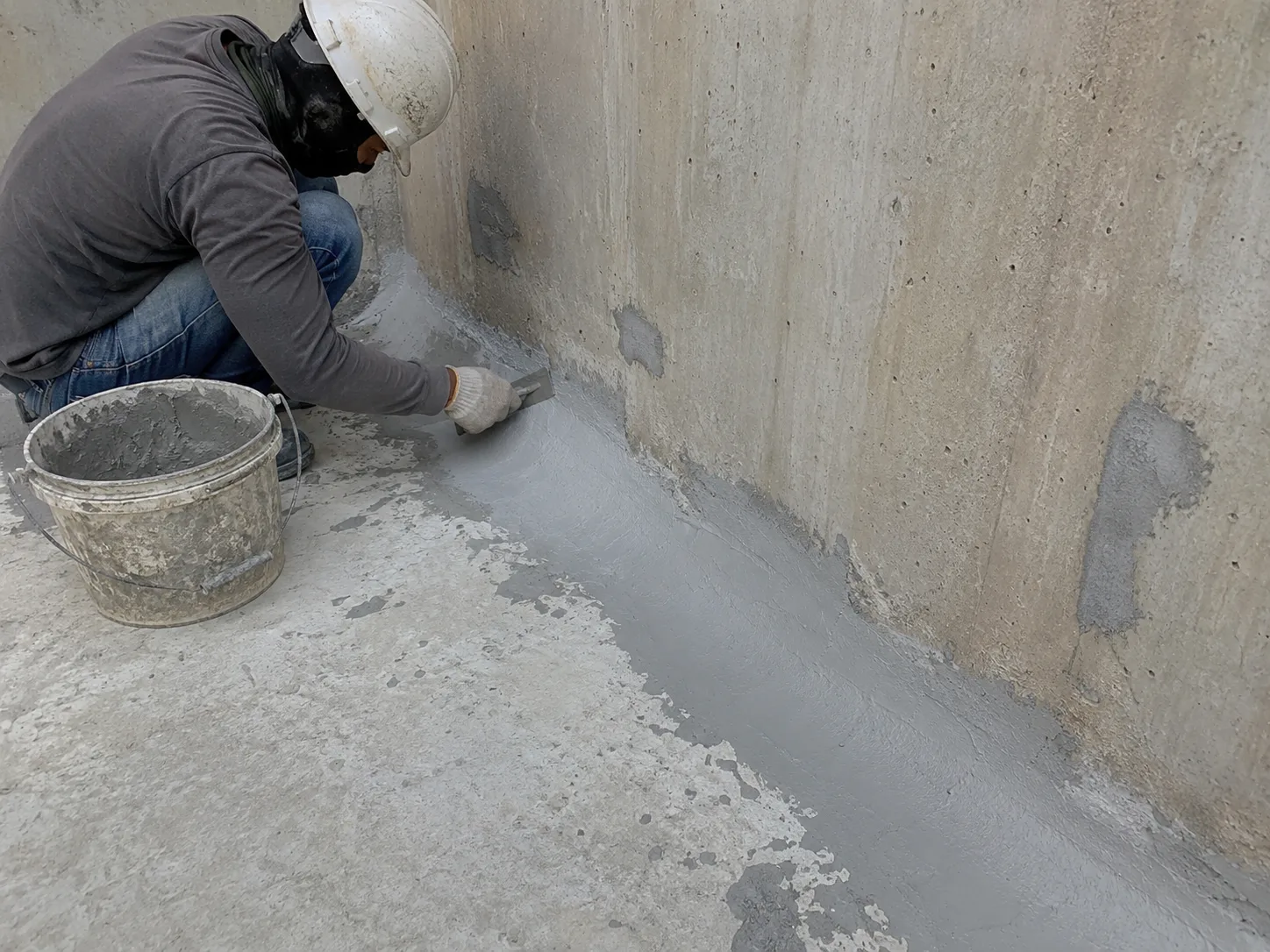 Concrete water tank primer and pore filling repair at wall-floor junction before polyurea coating