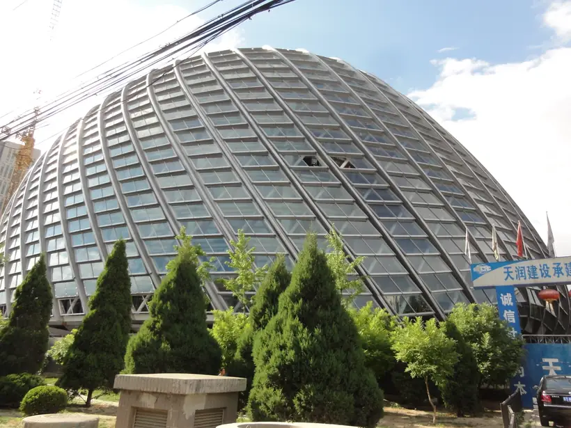 Curved steel roof frame with exposed protective topcoat