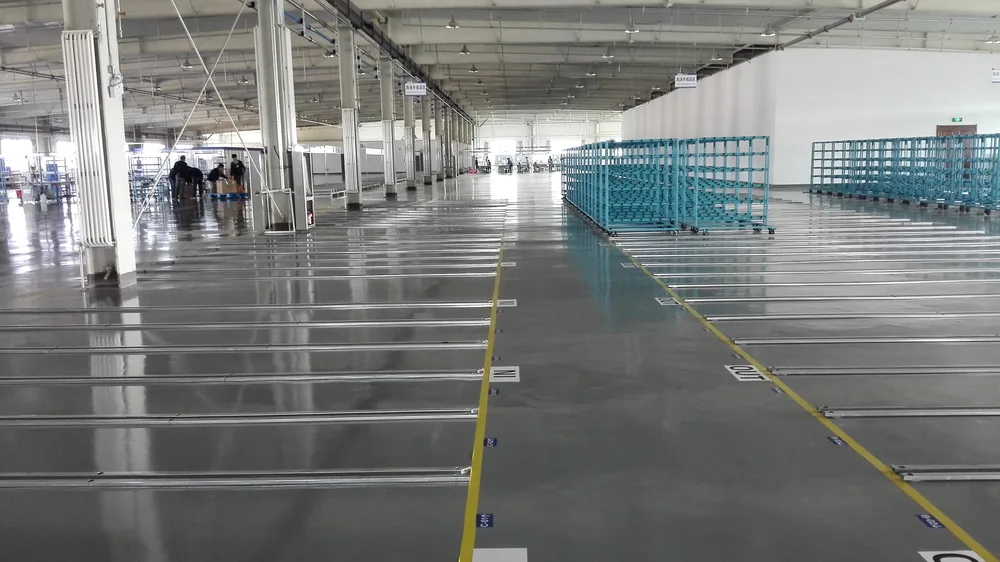 Automotive parts production floor with machinery and protective coating surface