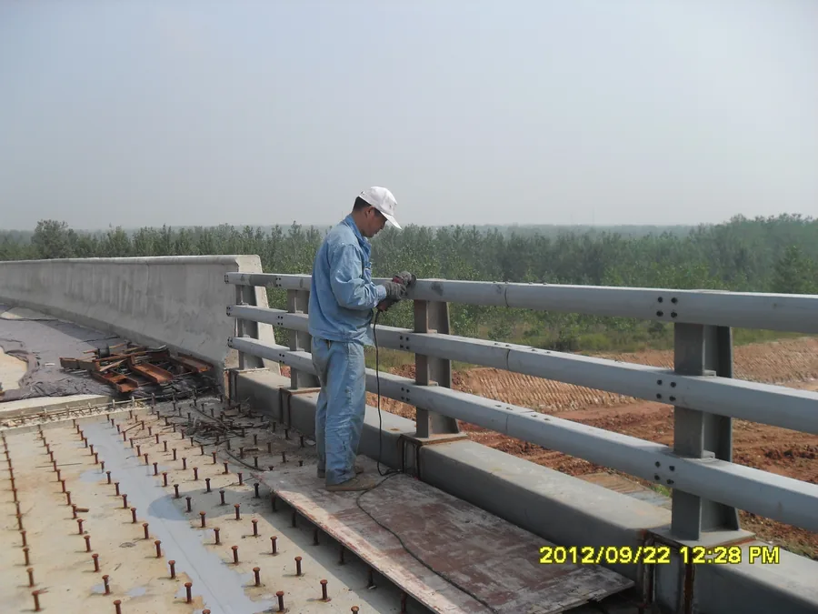 Worker applying anti-corrosion coating on bridge steel railing
