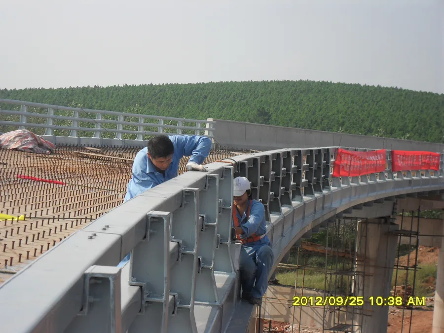Worker coating bridge railing edge and connection details