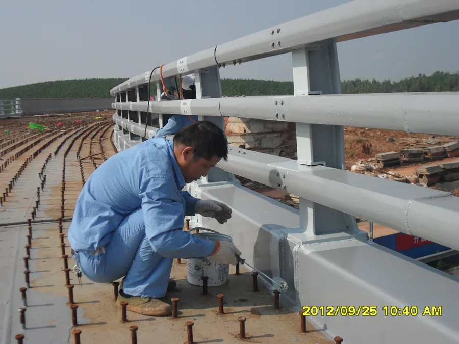 Bridge railing steel member with local repair and exposed topcoat