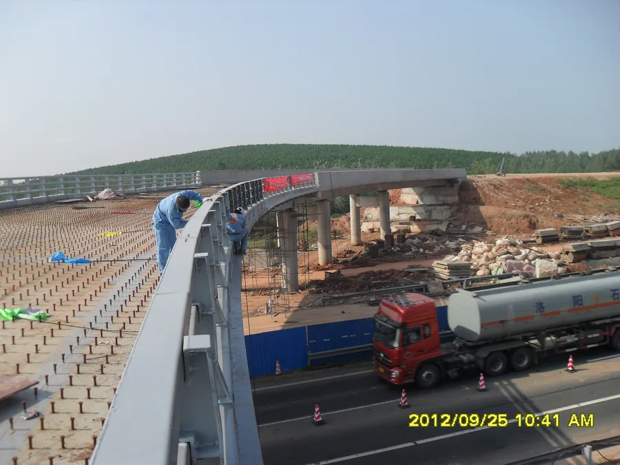 Finished bridge steel guardrail protection with exposed anti-corrosion topcoat