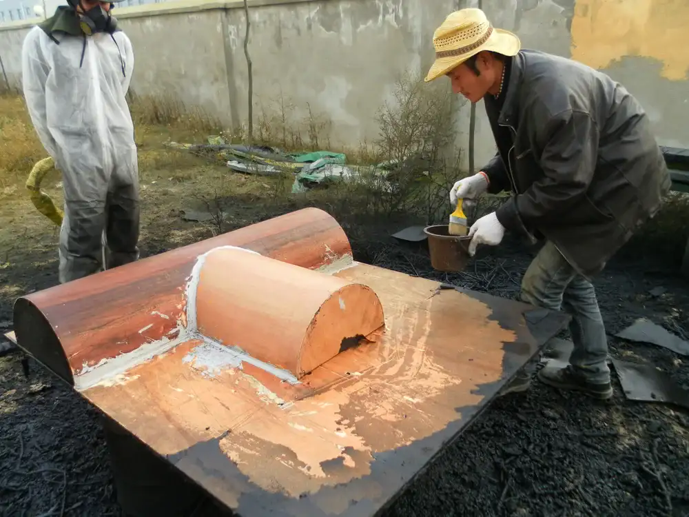 Worker applying local reinforcement material on dam equipment component