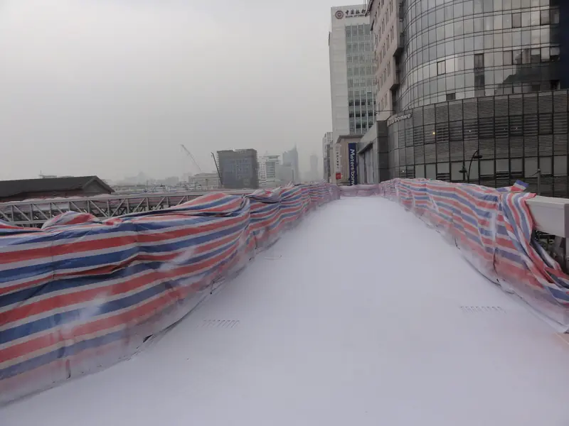Pedestrian overpass walkway surface with drainage detail and protective coating