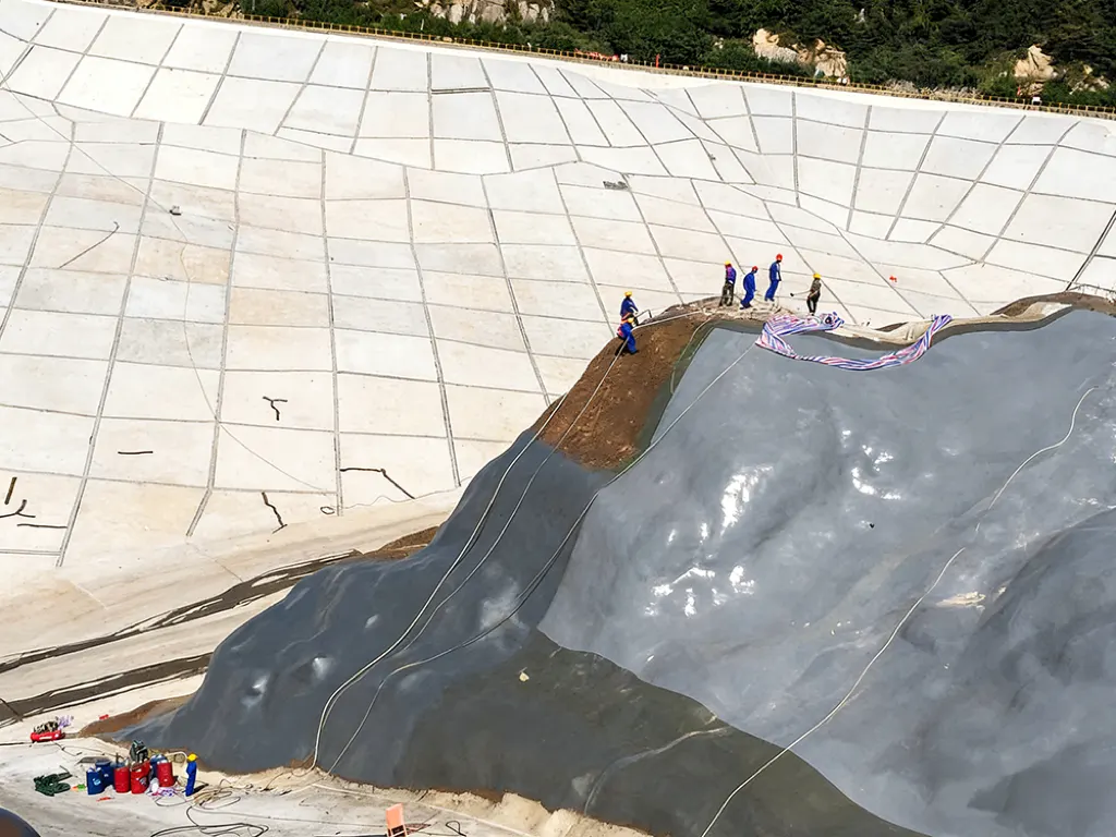 Finished waterproofing membrane on irregular reservoir slope transition