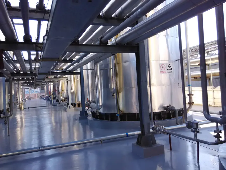 Industrial tank farm floor with protective coating and drainage channel