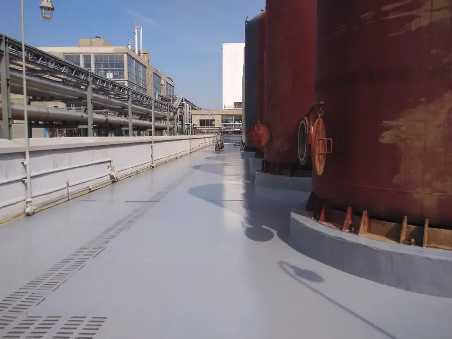 Protective coating around tank base and concrete containment area