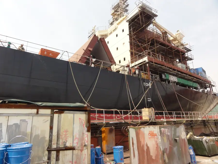Shipyard hull repair area with spray polyurea protective membrane