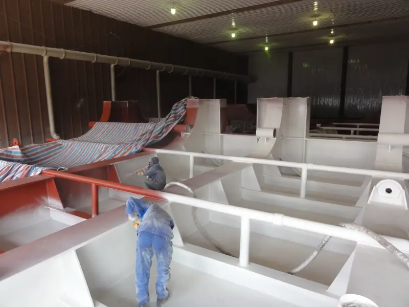 Worker spraying BW3-951 coating inside ship steel compartment