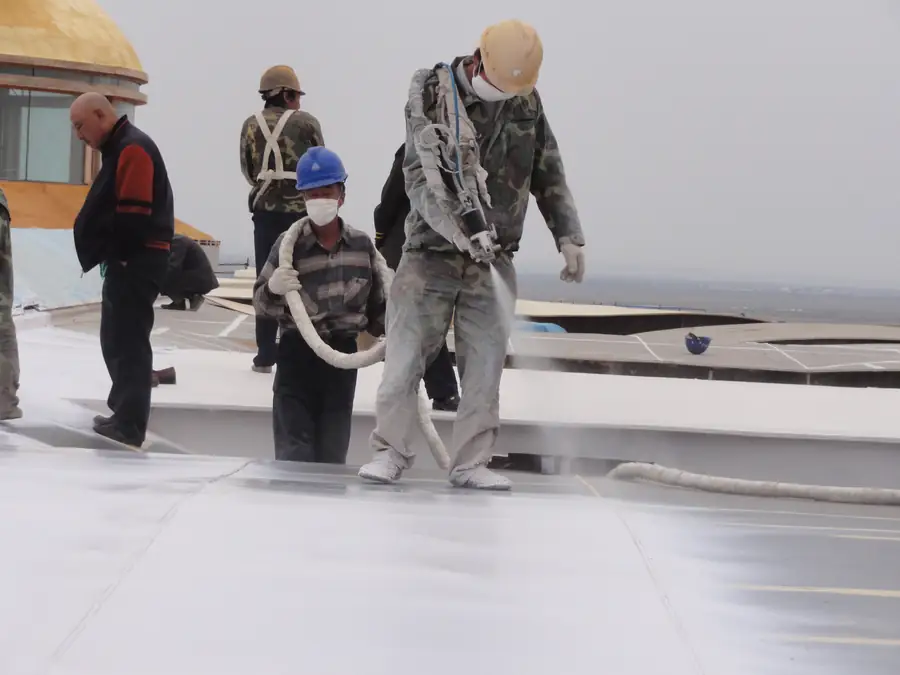 Workers spraying BW3-900 polyurea waterproofing coating on exposed roof