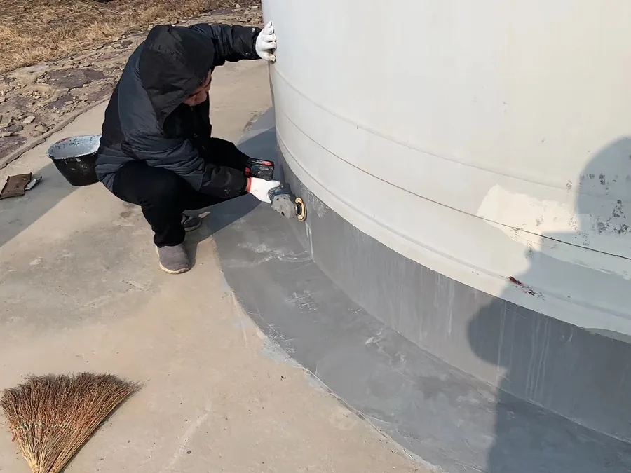 Worker grinding wind turbine base transition before polyurea coating